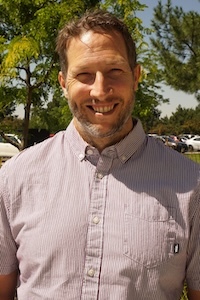 Staff member standing by tree