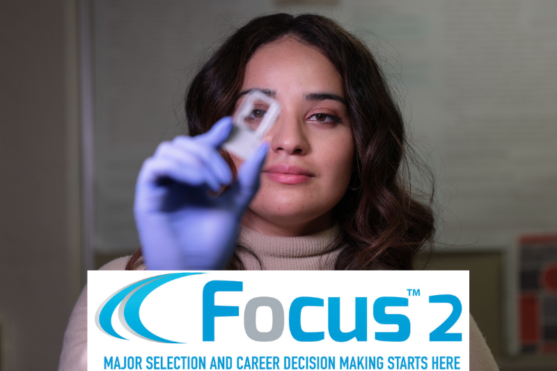 student in a lab looking through tweezers