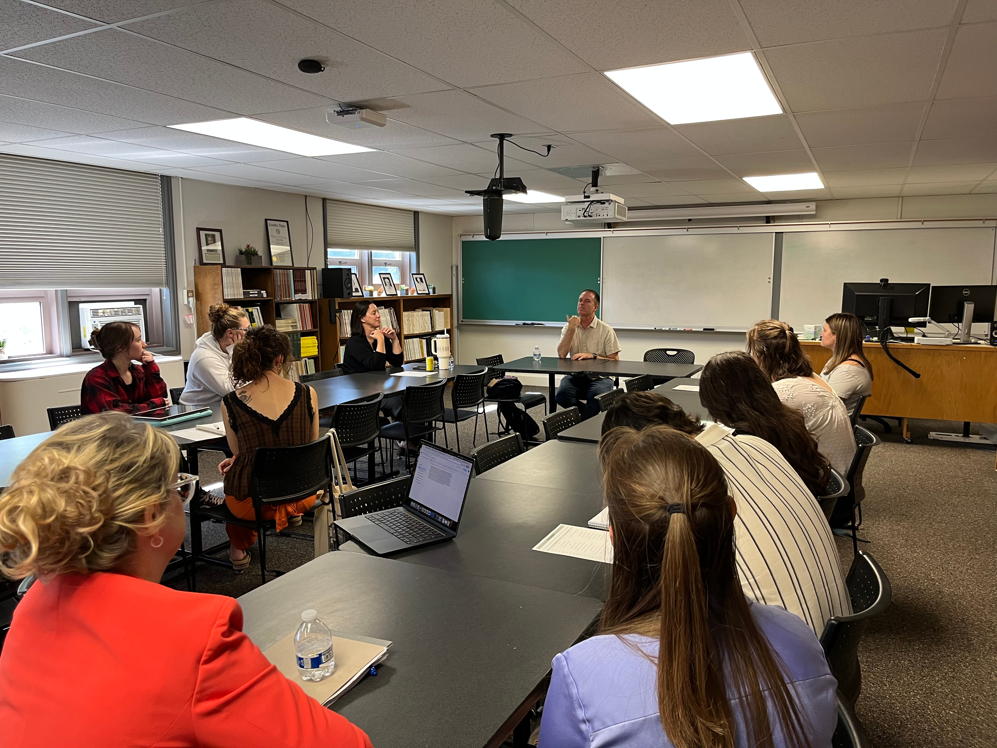 Nate Eaton sits at a table talking to students