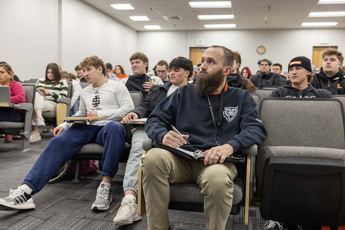 A student watches the professor and writes in his notebook