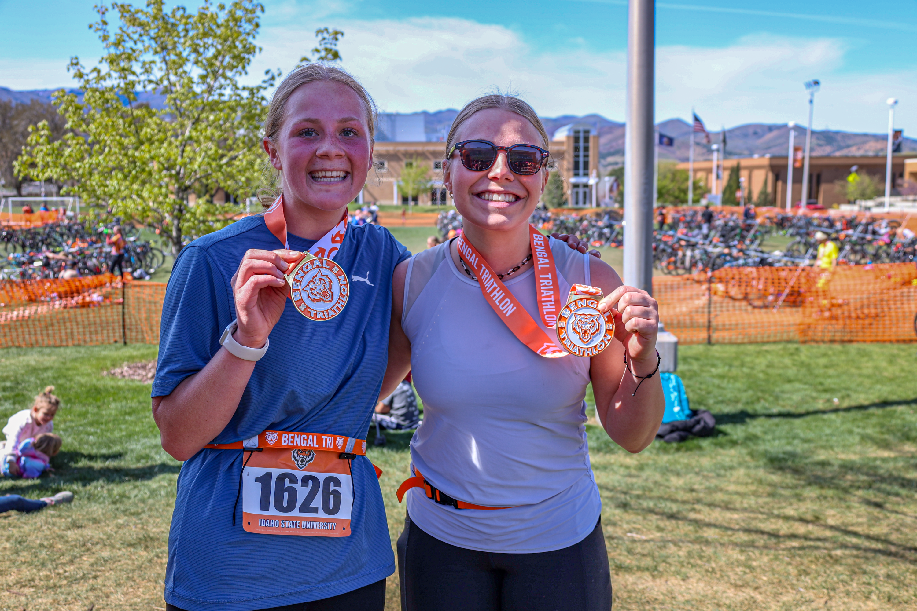 Two participants show off their medals in the Bengal Triathlon