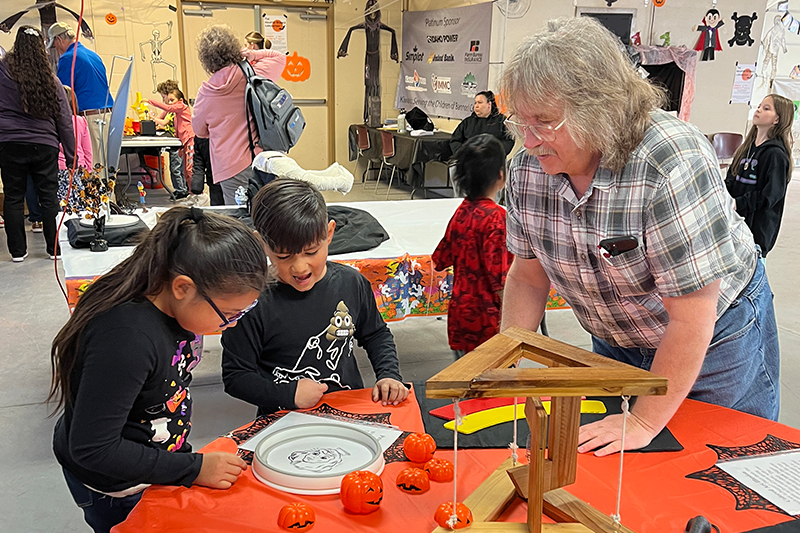 Steve Shropshire, professor of physics and lead organizer of the Haunted Science Laboratory, assists students with an activity during a 2024 field trip to the Haunted Lab.