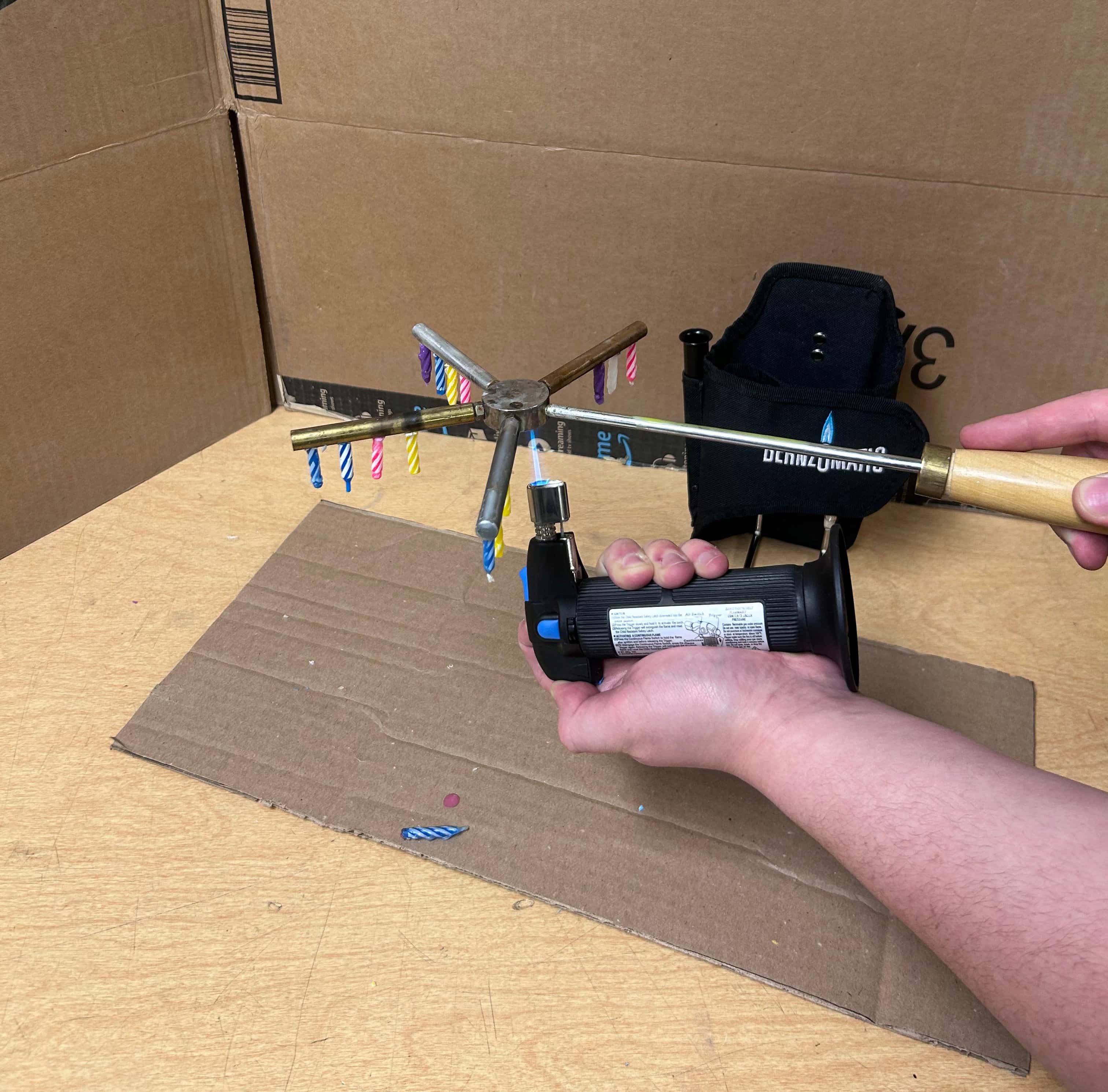 Performer holding the Conductometer aparatus and Bernzomatic torch  for the manual setup.