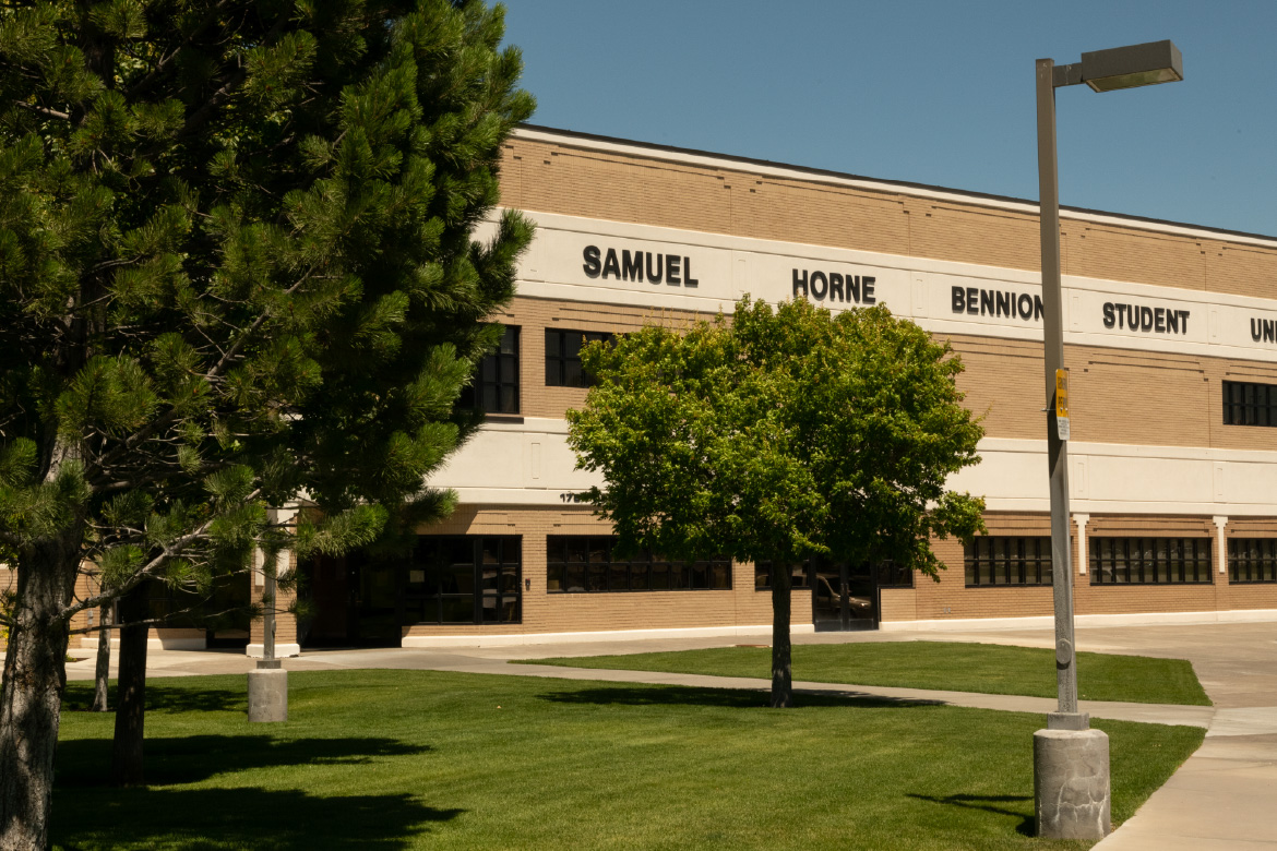 Exterior view of the Samuel Horne Bennion Student Union building with trees and lawn in the foreground on a sunny day.