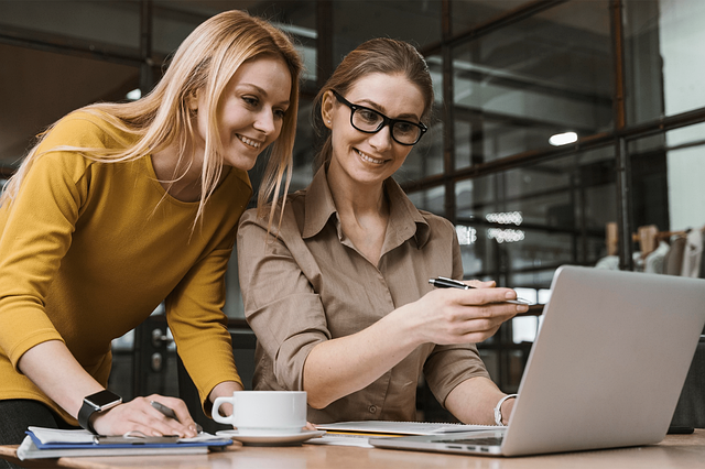 Two women collaborating together on a laptop