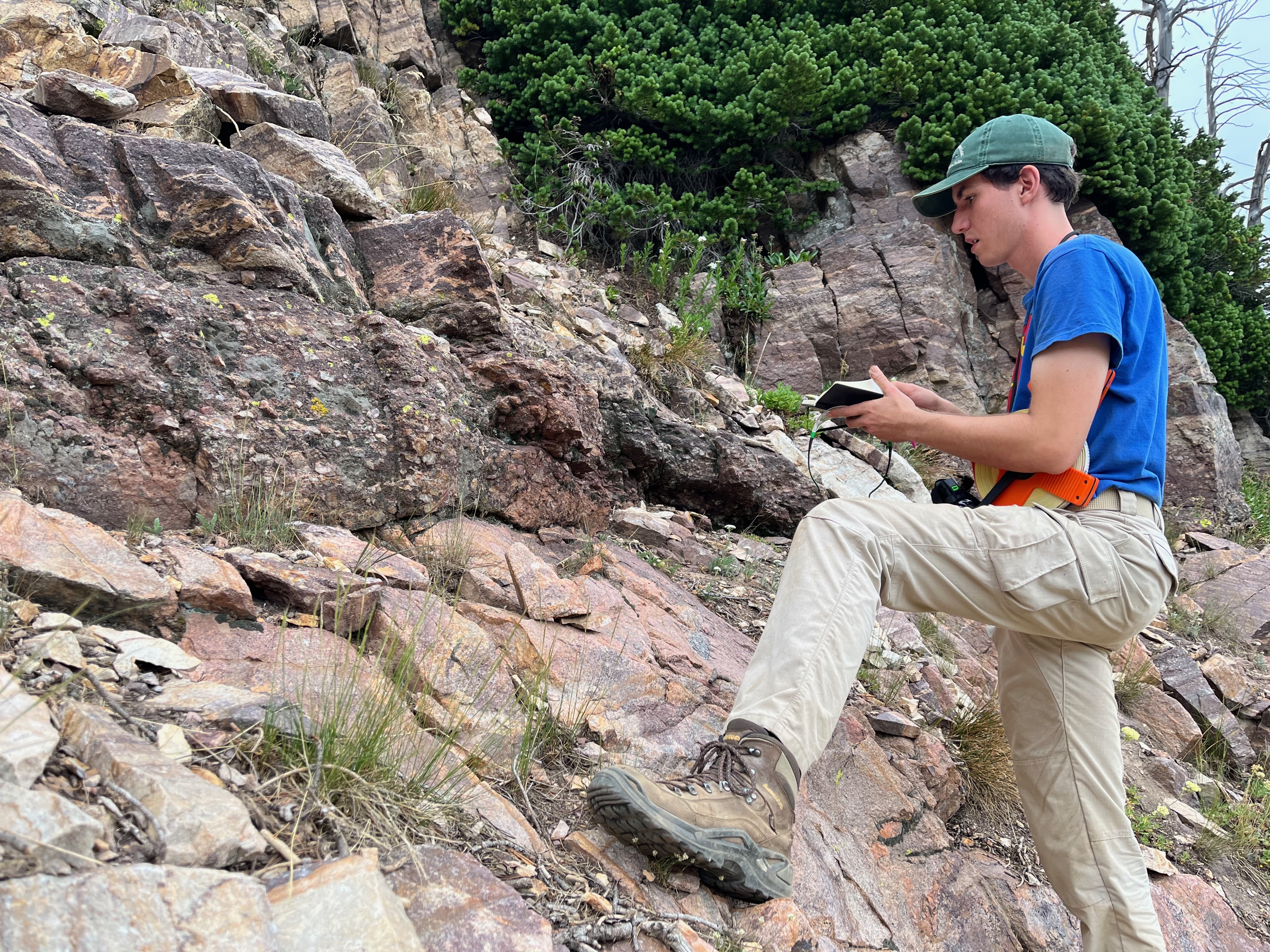 Zachary Ellia, graduate student at Idaho State University, examines an exposure of the Great Unconformity in the Teton Range.