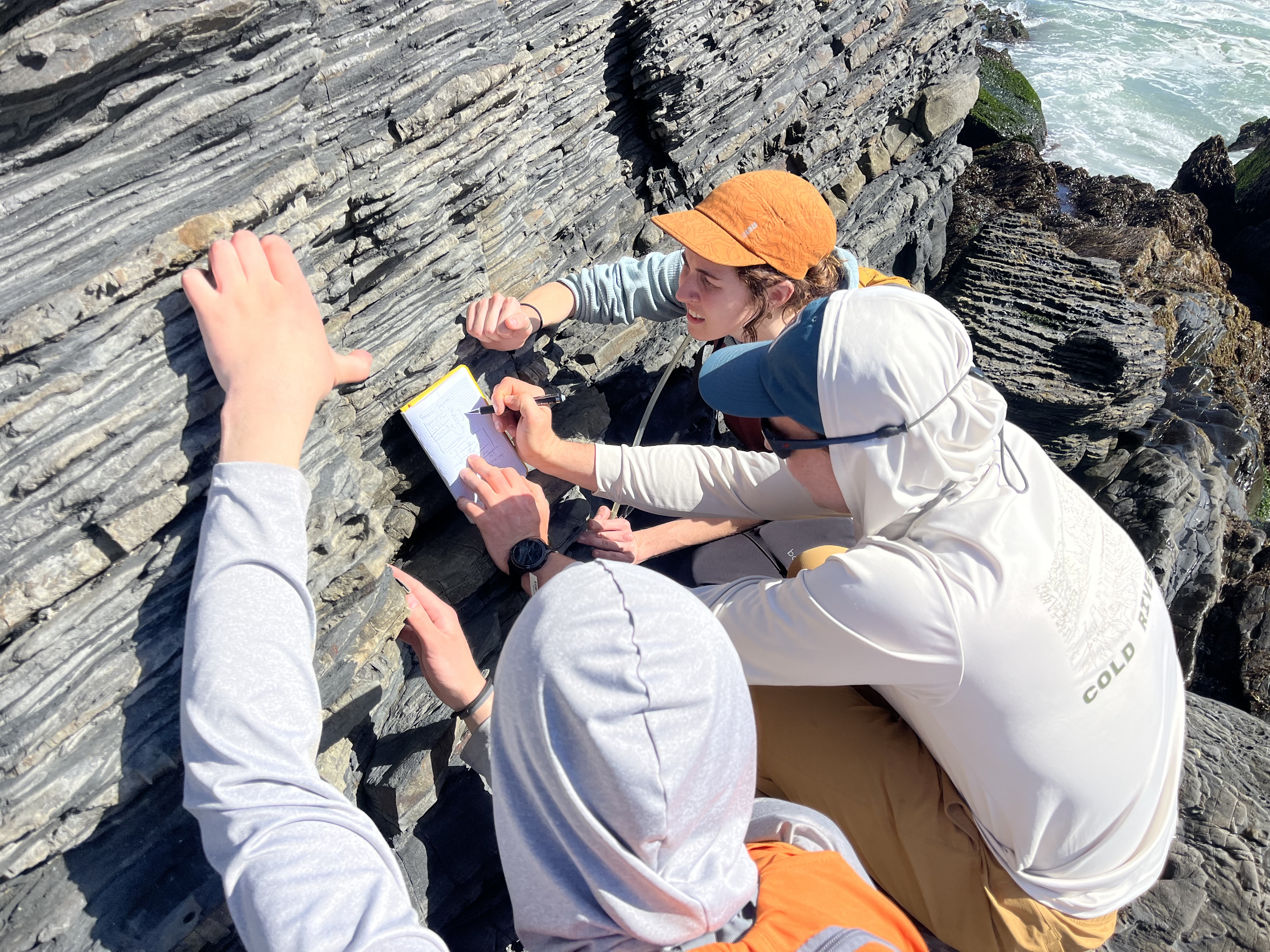 Along the Chile coast near Los Molles, Chance Ronemus and Tiana Hursh observe repeated upward-fining beds of sandstone and mudstone that are hallmarks of turbidite deposits.
